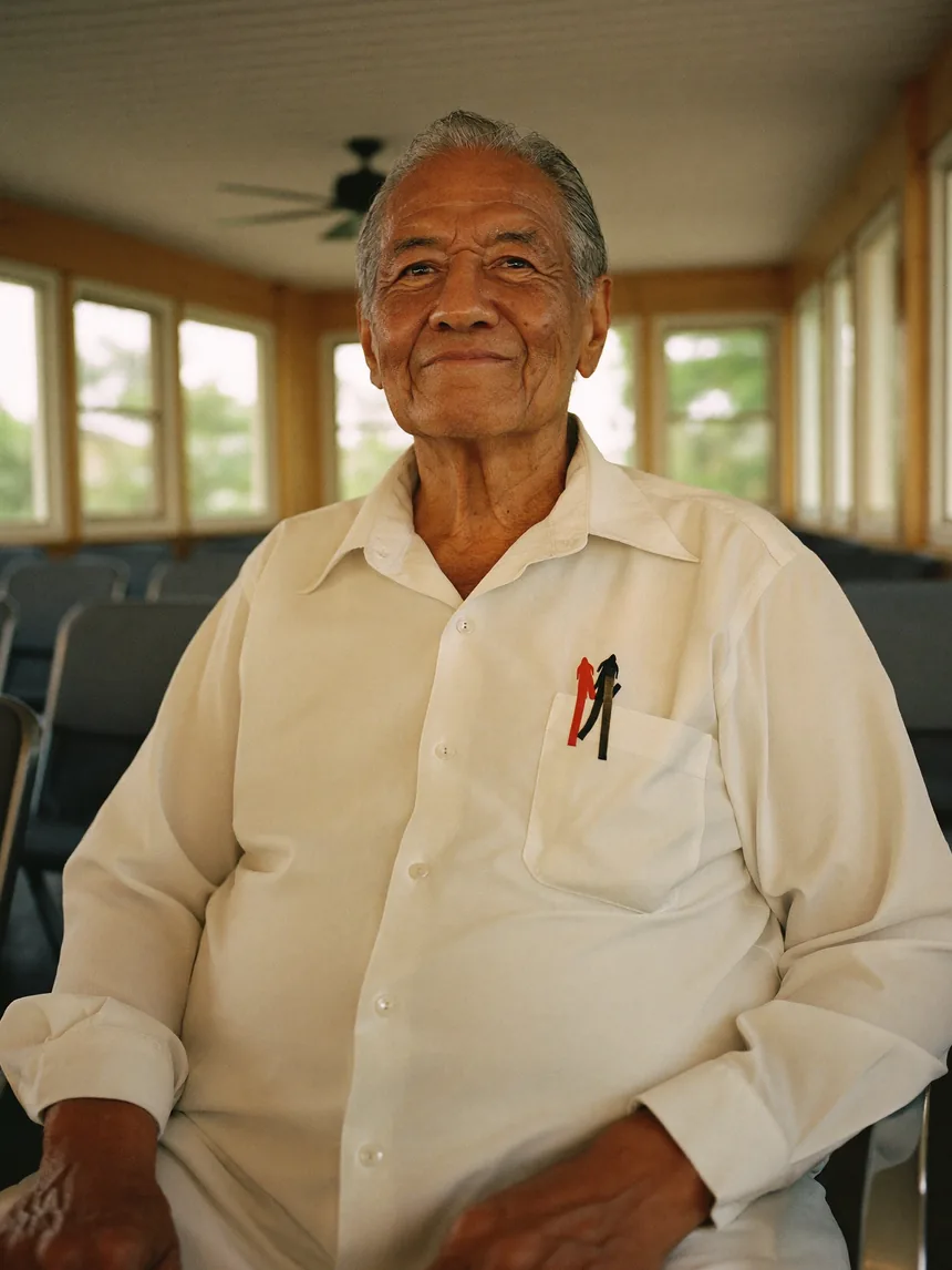 A Khmer elder seated in a community hall.