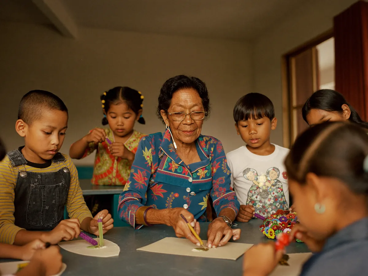 An elder teaching a traditional craft to a group of children.